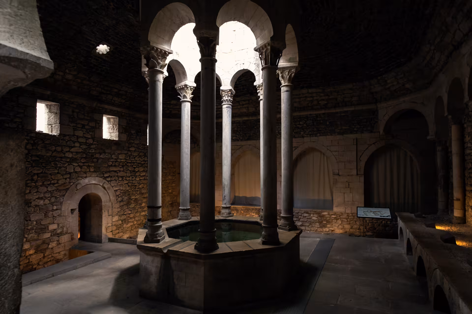 Romanesque stone hall with columns and central pool in Girona, stop on Costa Brava day tour from Barcelona