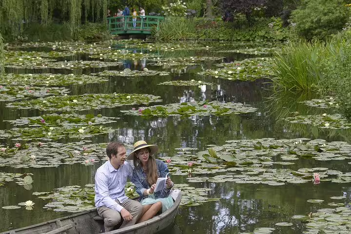 Couple in rowboat on Monet's lily pond at Giverny with Japanese bridge in background