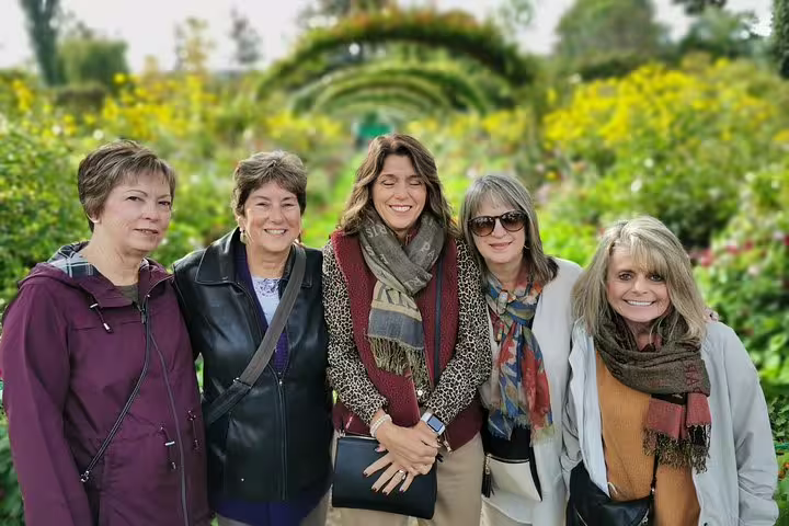 Small group photo in Monet’s Giverny gardens during full-day private guided tour with hotel pickup