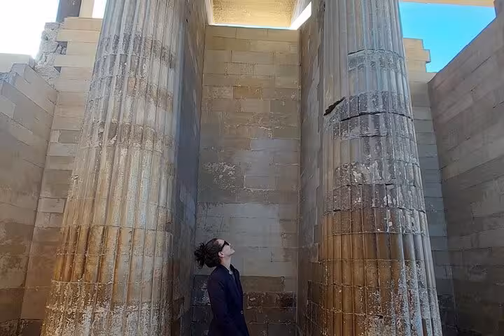 Traveler admiring towering columns at Saqqara complex on Giza Great Pyramid interior, Sphinx and Serapeum tour