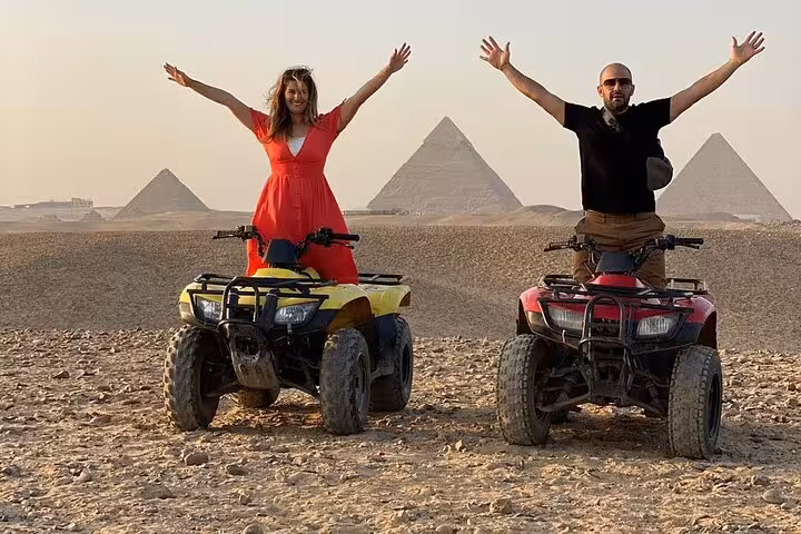 Couple on quad bikes with Giza Pyramids backdrop on private tour featuring ATV ride, camel trek and dinner cruise