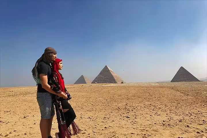 Couple watching the Giza Pyramids in Cairo desert on a private tour with Memphis, Sakkara and Dahshur