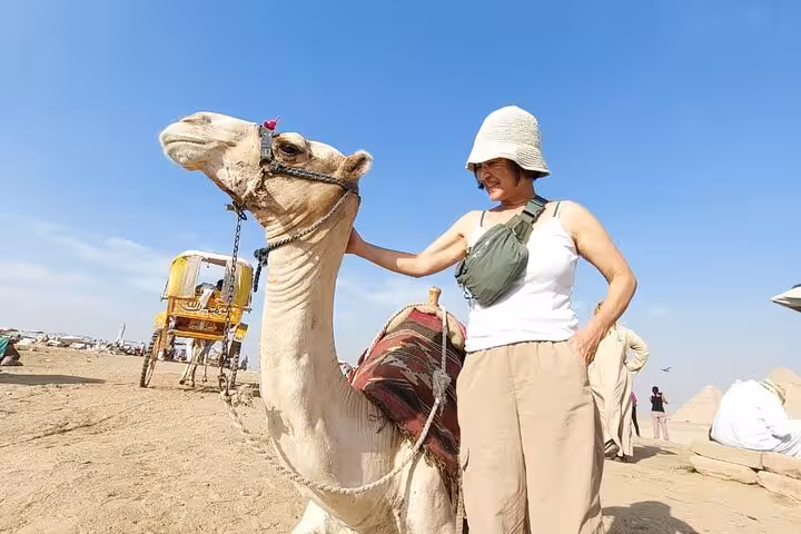 Tour guest with camel at Giza Plateau on an all-inclusive private trip from Cairo Airport transfer