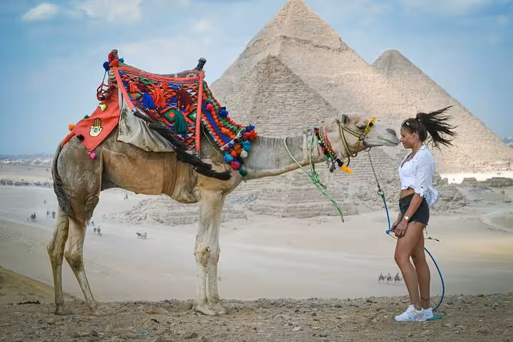 Free camel ride at the Giza Pyramids with decorated camel and traveler on a half-day private Cairo tour