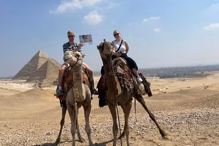 Tourists on camel ride overlooking the Giza Pyramids, Egypt, with skip-the-line entry ticket and site access
