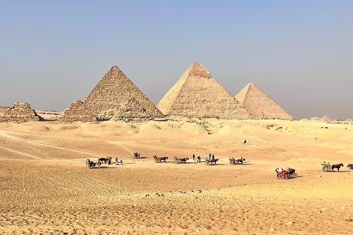 Wide view of the Giza Pyramids plateau with camel rides, part of Cairo day tour by bus from Hurghada
