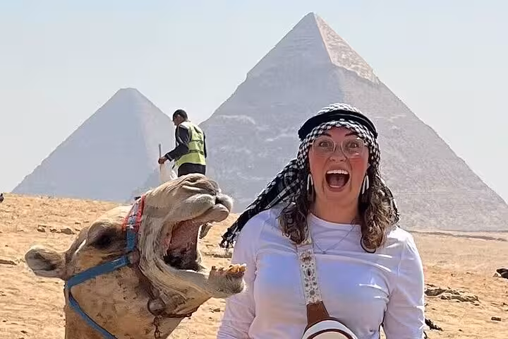 Tourist and camel photo at Giza Pyramids on half-day pyramids tour, with iconic 9-pyramids view backdrop