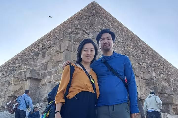 Travelers pose by the Great Pyramid of Giza on a private Cairo tour with pyramids, citadel, bazaar and felucca