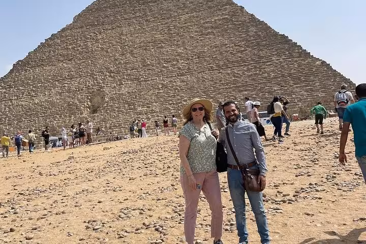 Couple posing near the Great Pyramid of Giza on a private tour, combining camel ride, ATV adventure and Nile cruise