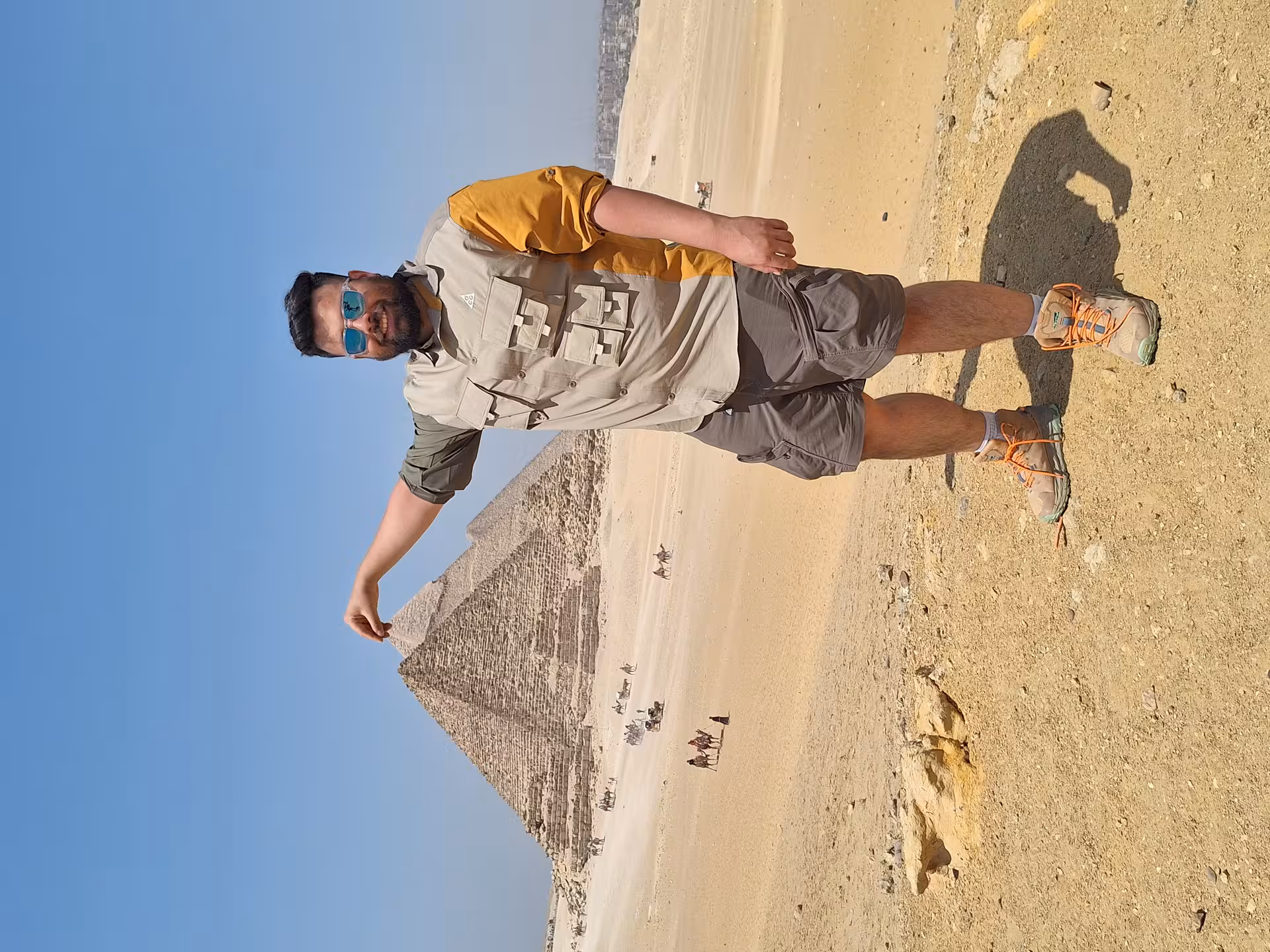 Traveler enjoying a creative photo opportunity at the Giza Pyramids, highlighting the stunning Egyptian desert scenery.