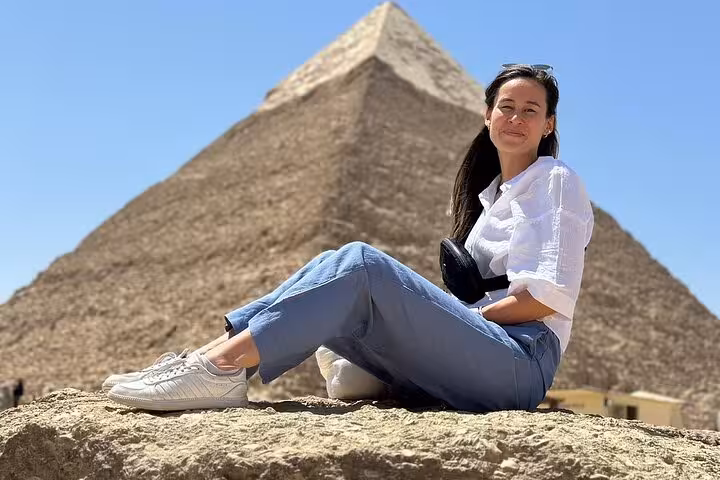 Traveler relaxing in front of the Great Pyramid on a half-day Giza Pyramids and Sphinx tour with lunch