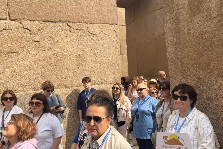 Tour group explores ancient limestone corridor at Giza Pyramids, guided Cairo day tour experience