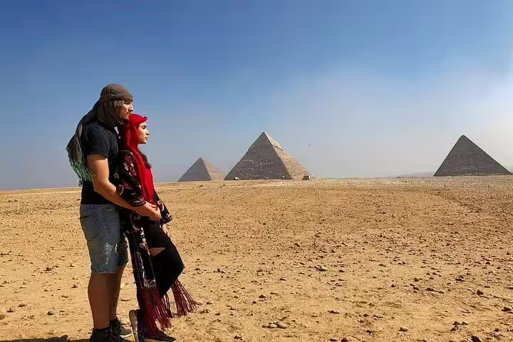 Travelers posing in the desert with Giza Pyramids on a private Alexandria Port shore excursion to Cairo