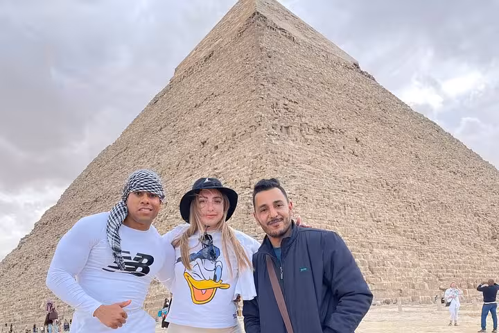 Travelers posing at the Great Pyramid of Giza on a private Cairo tour with guide, pyramids day trip