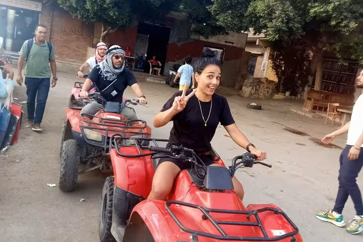 Guests riding red quad bikes in Cairo on a private Giza Pyramids and Sphinx tour with ATV adventure
