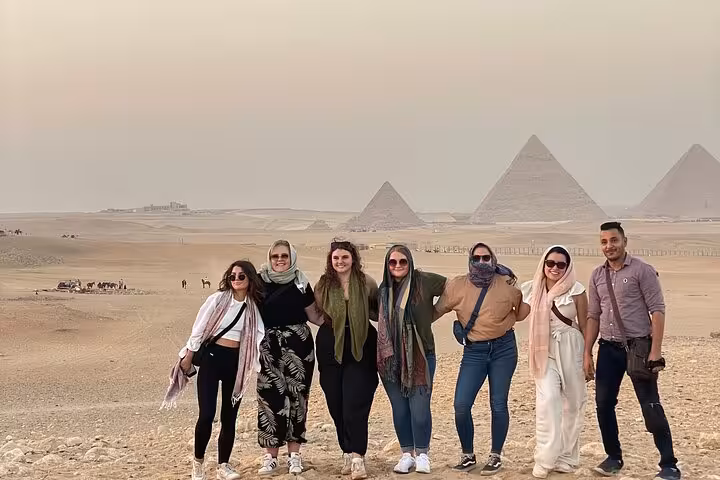 Group photo in Giza desert with pyramids backdrop after quad bike ride, guided ATV tour with transfers
