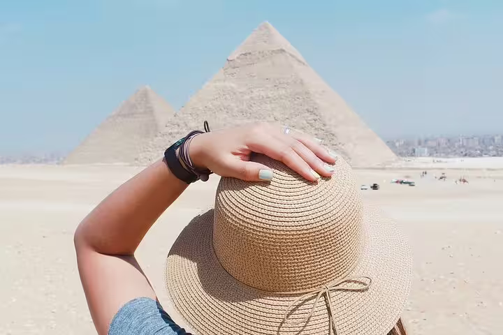 Traveler in sun hat gazing at Giza Pyramids on a royal expedition tour to Giza, Saqqara and Dahshur