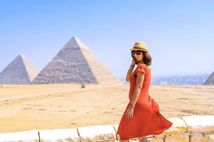 Traveler in red dress at Giza Pyramids viewpoint with skip-the-line entry ticket site access in Cairo