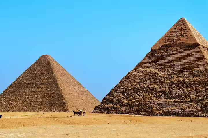 Two Giza pyramids under clear blue sky, popular Cairo Airport layover tour photo stop in Egypt desert
