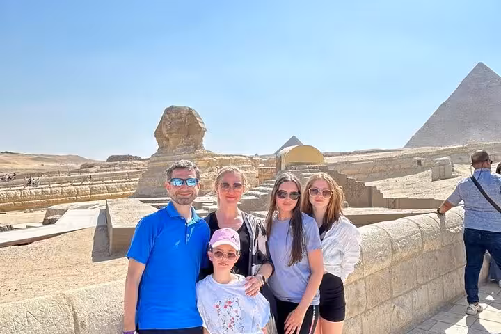 Family photo at the Sphinx and Giza Pyramids on a private trip with entry tickets, camel ride, quad adventure and lunch