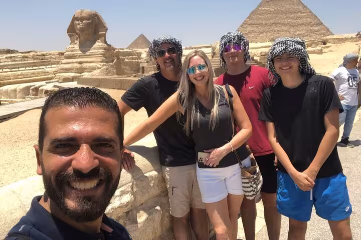 Private tour group selfie by the Sphinx and Giza Pyramids, Cairo day trip to Saqqara and Memphis with camel ride