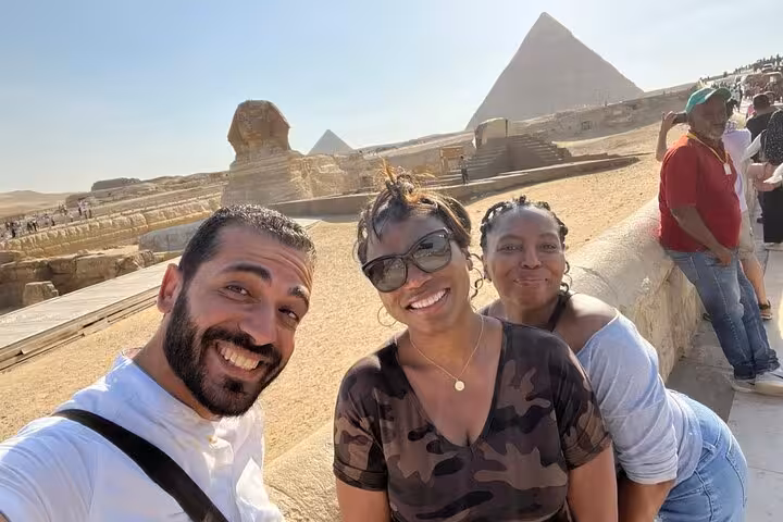 Friends selfie at Giza Pyramids and Sphinx viewpoint on private tour with camel ride and Nile dinner cruise