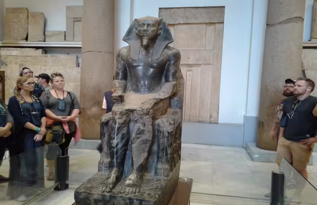 Tour group viewing seated pharaoh statue inside Egyptian Museum Cairo on private Giza day tour