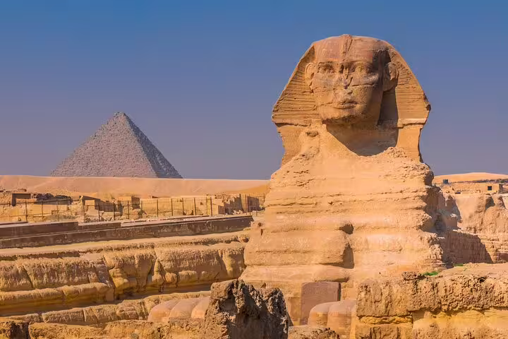 Wide view of the Great Pyramid of Giza with visitors and camels on a private guided tour including transfers and tickets