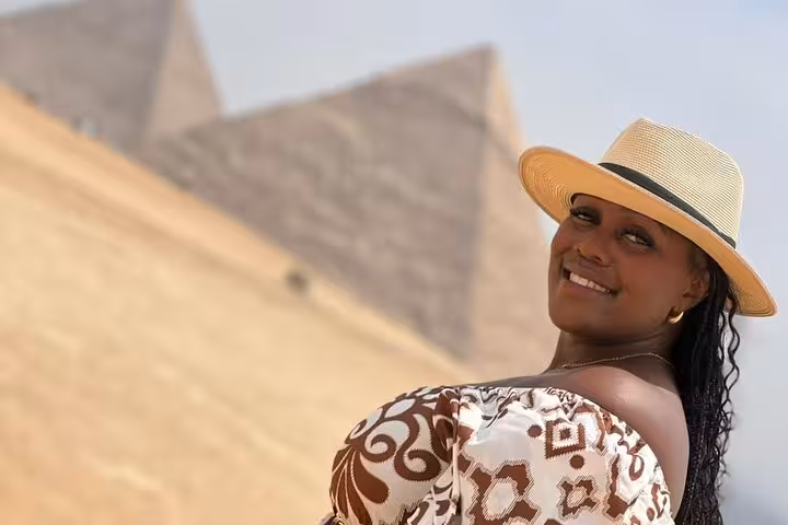 Smiling traveler at the Giza Pyramids on a private guided tour, Cairo Egypt, photo stop in the desert