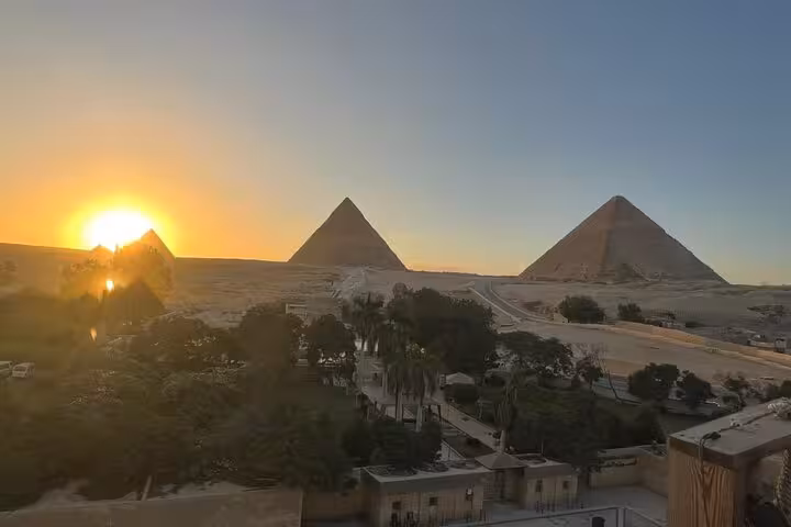 Sunrise view of the Giza Pyramids plateau in Cairo, a highlight of private Giza and Grand Egyptian Museum tour