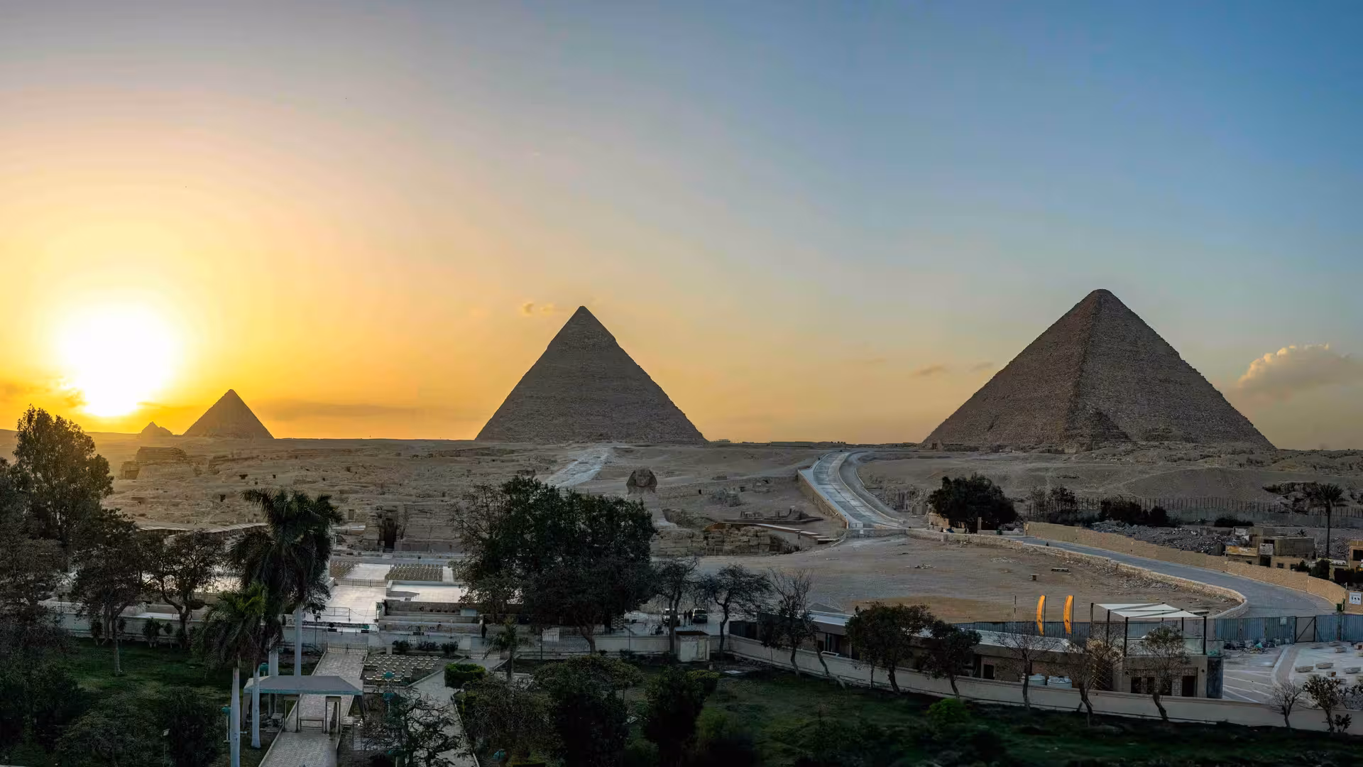 Panoramic sunset view of the Giza Pyramids and Sphinx complex, Cairo, Egypt