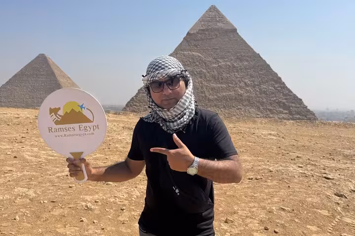 Private Giza Pyramids tour guide posing at Khufu pyramid, ideal for Sphinx and Grand Egyptian Museum visit