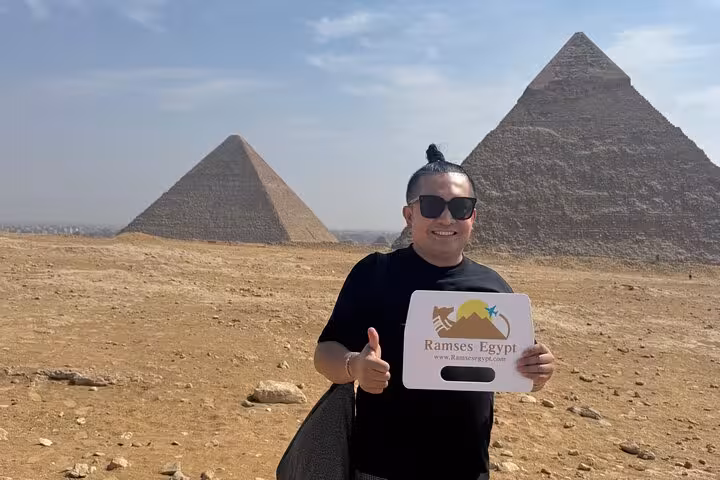 Traveler posing at Giza Pyramids desert viewpoint on private Giza tour with Sphinx visit and Grand Egyptian Museum