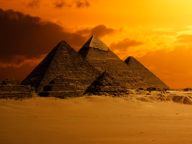 Giza Pyramids at sunset under dramatic sky, Golden Cairo tour featuring Great Pyramid and desert views