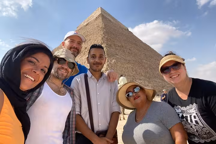 Private Giza Pyramids tour group selfie with local guide at Great Pyramid, Cairo day trip experience