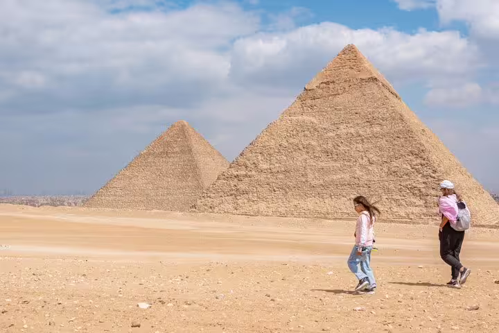 Travelers walking by the Great Pyramids of Giza on a full-day tour from Port Said, Cairo Egypt
