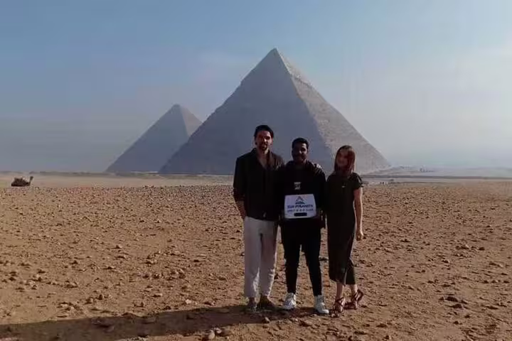 Travelers with guide in front of Giza Pyramids on Alexandria Port to Cairo day trip including Egyptian Museum