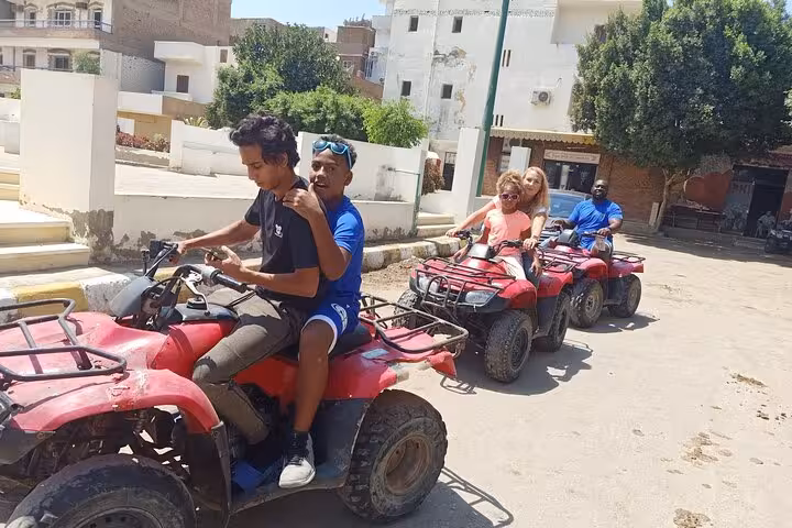Guests riding quad bikes in Giza village streets, part of private Giza Pyramids, Sphinx and ATV tour