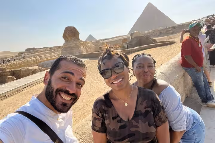 Travelers with guide at Giza Sphinx viewpoint, pyramids backdrop, all-inclusive tour with pyramid entry and camel ride