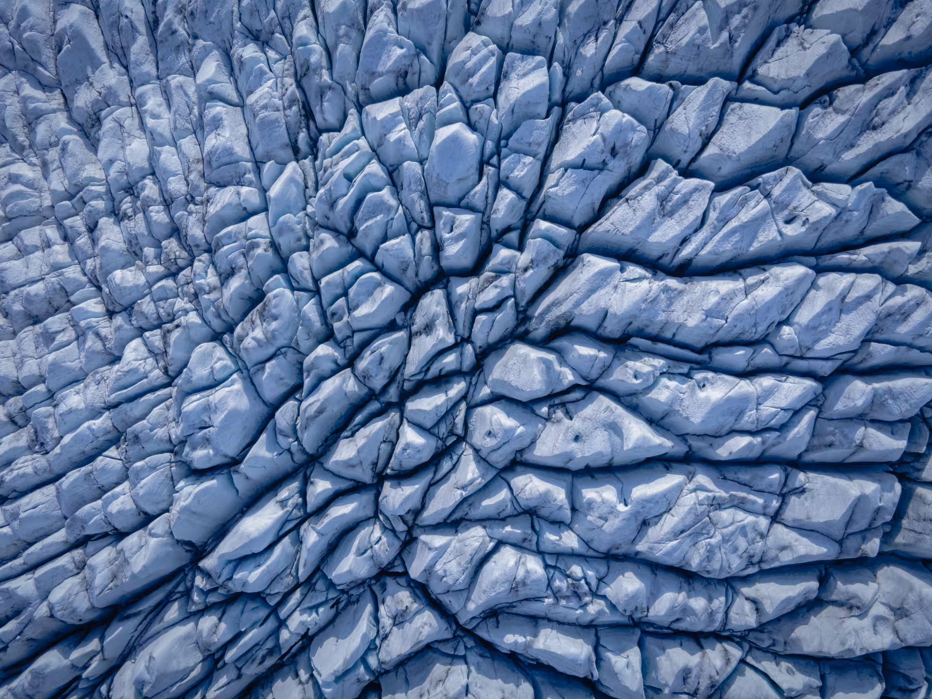 Aerial view of glacier ice formations with radial crack patterns, Iceland