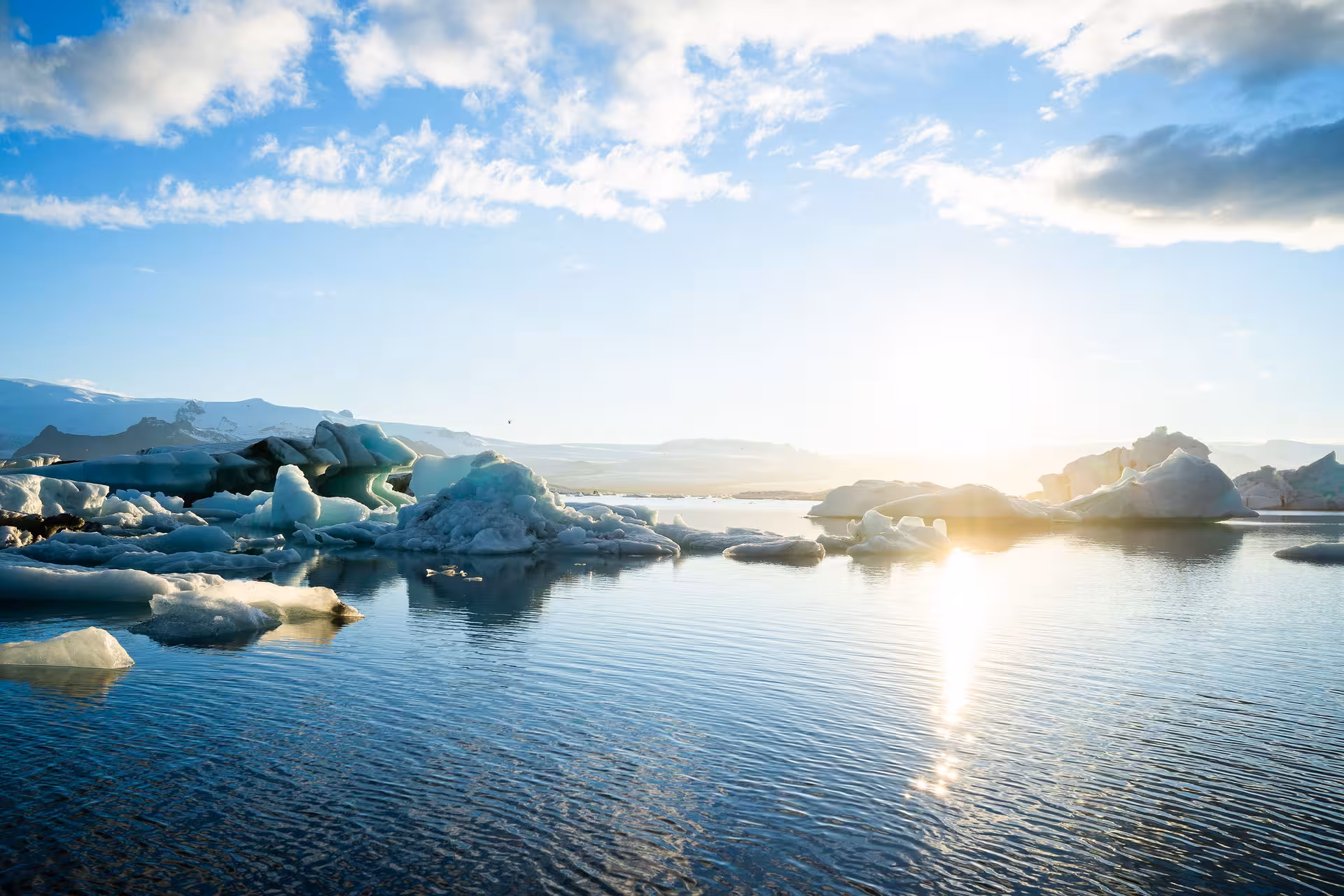 Floating icebergs on Jökulsárlón Glacier Lagoon under a bright sun and blue sky, Iceland