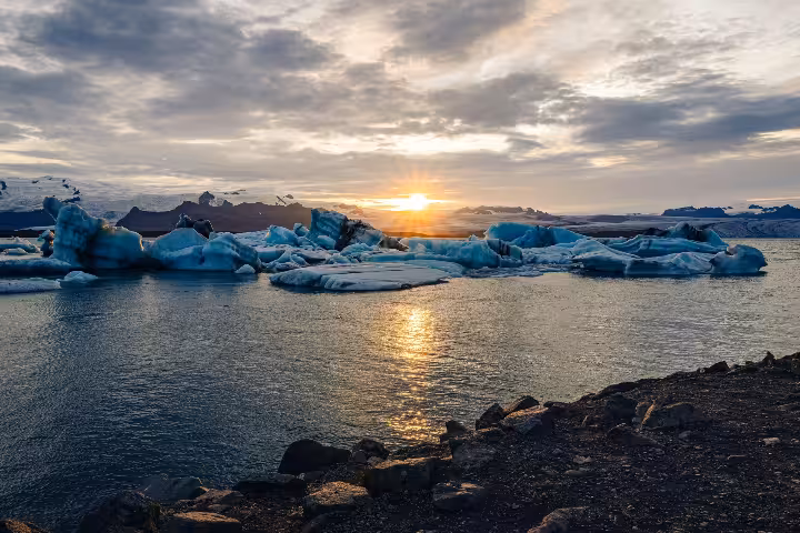 Icebergs floating on Jökulsárlón Glacier Lagoon at golden sunset in Iceland