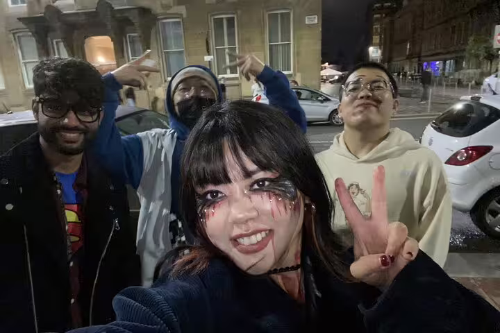 Group of friends in Halloween makeup posing for selfie on Glasgow ghost tour at night