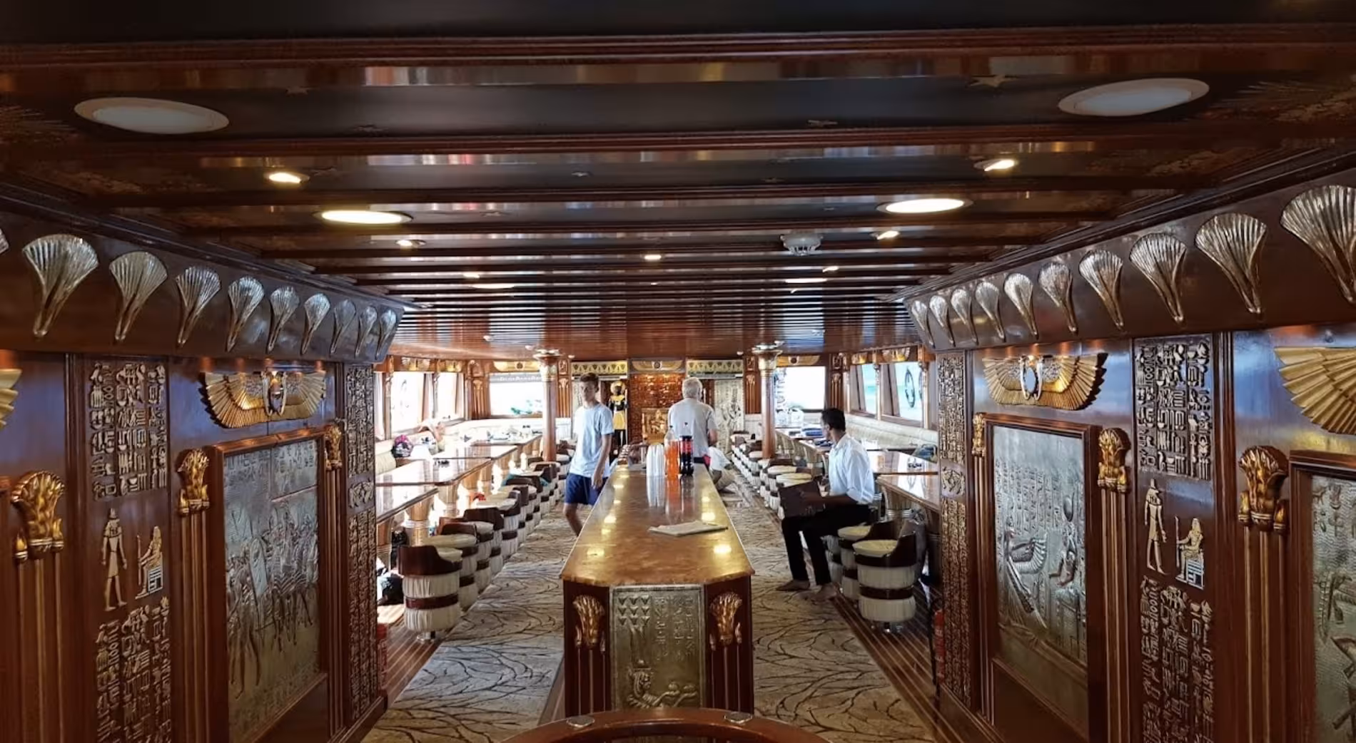 Egyptian-themed interior bar lounge on a glass bottom boat in Marsa Alam with ornate hieroglyphic decor