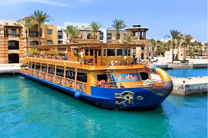 Colorful Egyptian-themed glass bottom boat docked at Marsa Alam marina with turquoise waters