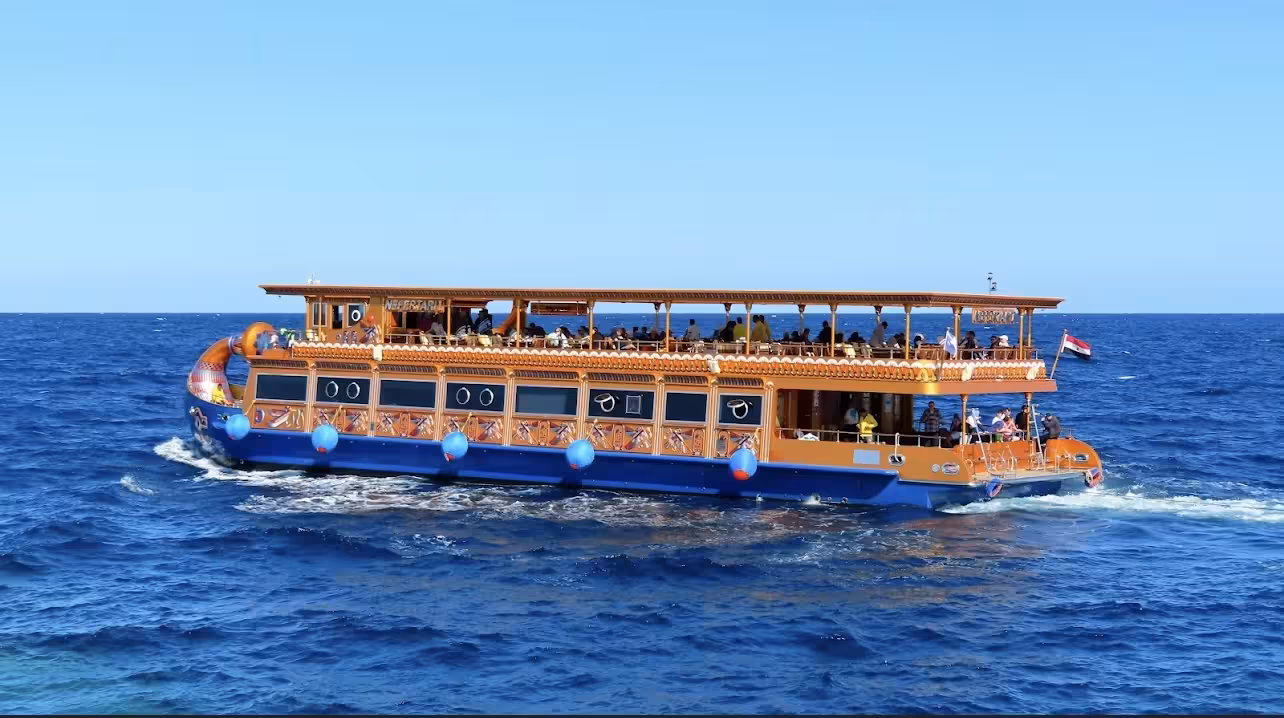Colorful glass bottom boat Nefertari sailing in the Red Sea near Marsa Alam with tourists on deck