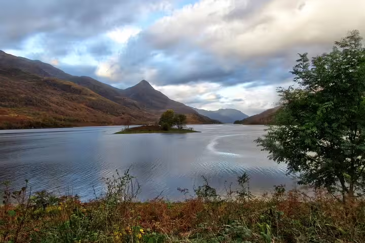 Loch in Glencoe Highlands with small island and misty peaks, scenic stop on Glencoe adventure tour
