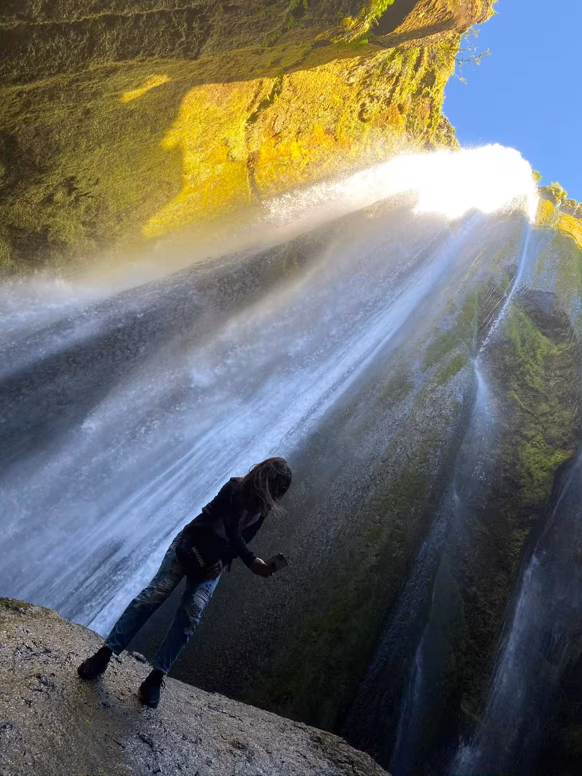Traveler standing behind Gljufrabui hidden waterfall on South Coast Iceland private day trip from Reykjavik