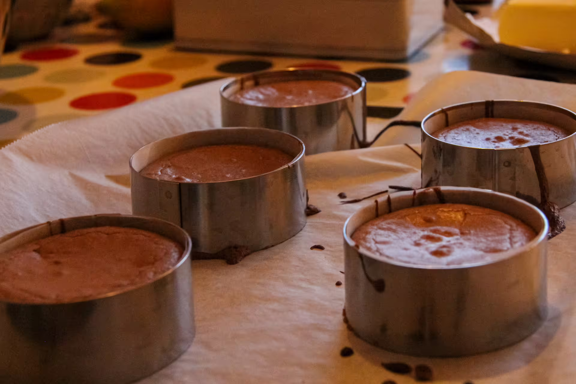 Gluten-free chocolate cake batter in round metal baking molds on parchment paper in Paris cooking class