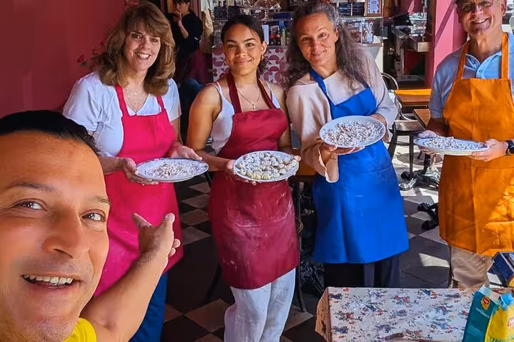 Smiling participants display handmade pasta dishes during Chef Christian's Gluten-Free Roman Feast Cooking Class.